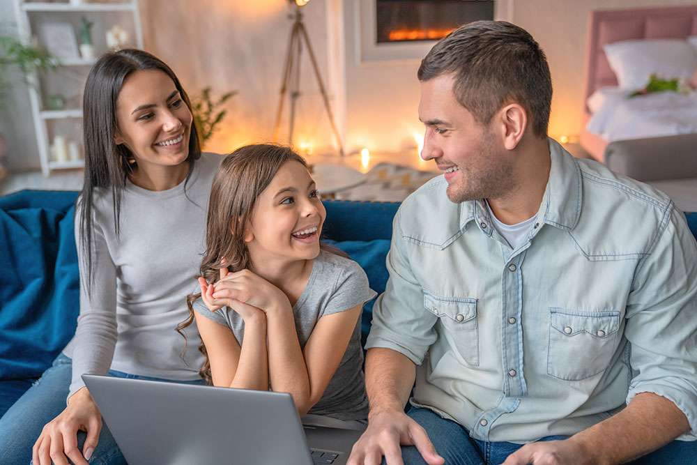 Family of three with a mom, dad, and little girl reading the LifeQuote About Us page