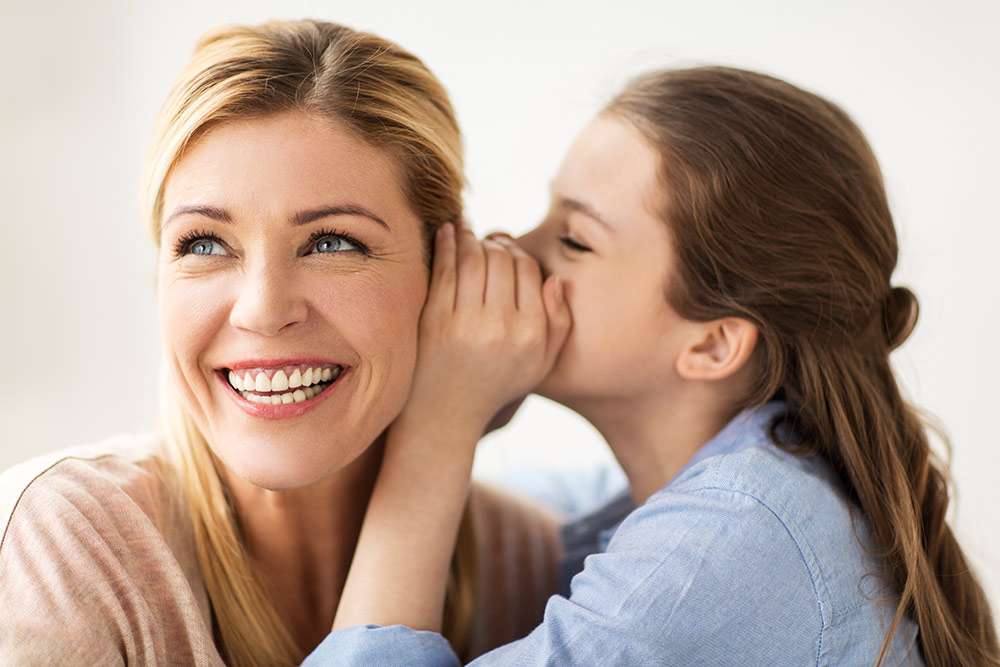 A daughter telling her mom a secret - maybe one of our secrets for how to get life insurance!