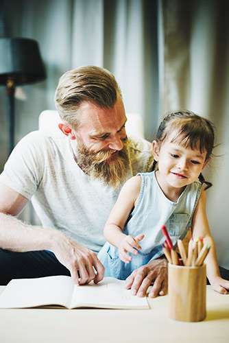 Father and daughter coloring together.