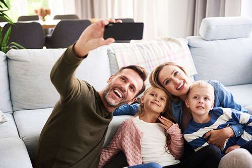 Dad taking a selfie with his wife and two kids.