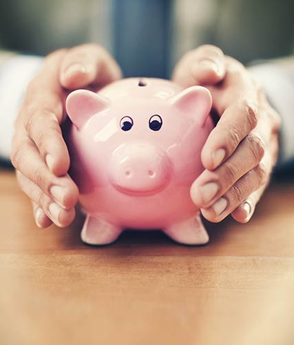 Hands holding a piggy bank, symbolizing the cash value component of a permanent life insurance policy.