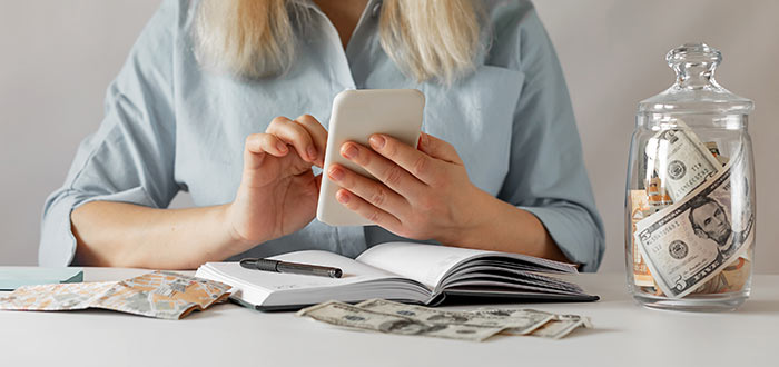 Close-up of woman using a calculator to estimate her monthly budget and life insurance payments