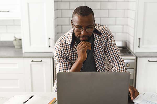 Man using a laptop to research what happens when a term life insurance policy matures