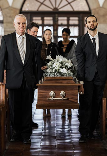 Pallbearers carrying a coffin into a church