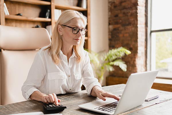 Woman using her laptop to look up how much can you borrow against your life insurance policy