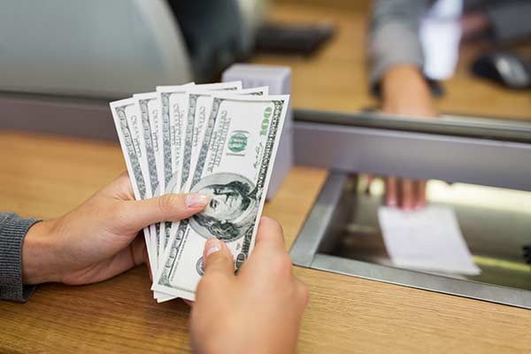 Bank teller remitting $500 to an account holder