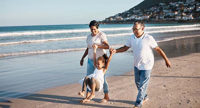 little girl spending time with her grandparents at the beach