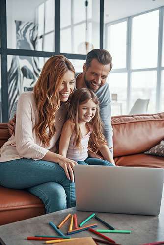 family-of-three-looking-up-term-life-insurance-rates Family of three looking up information on a laptop.