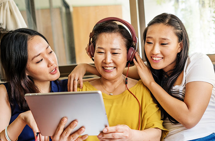 Mother and two daughters sitting on a couch using a laptop to research what happens to term life insurance if you don't die
