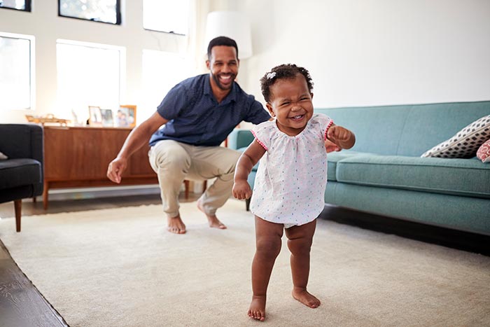 Father and daughter playing together in the living room.