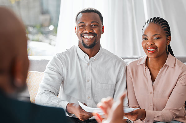 Young couple meeting with their life insurance agent to talk about permanent life insurance, cash value, and their 401k.