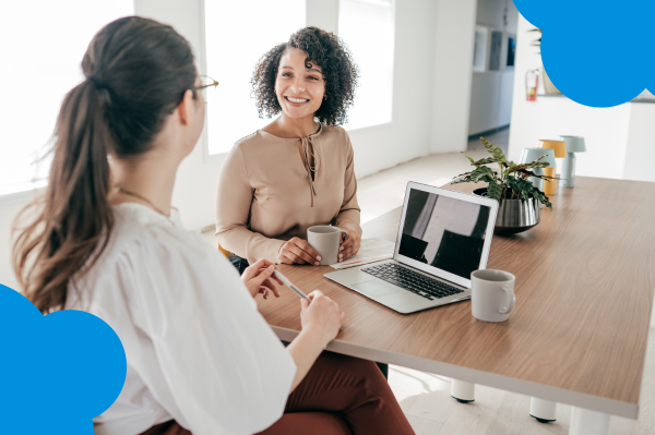 Employer and employee meeting in a bright office, reviewing how to coordinate term life insurance with company-provided benefits in their 40s.