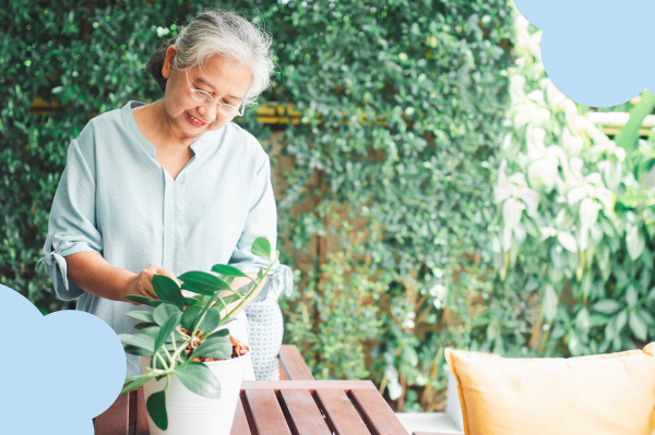 Smiling older woman caring for a potted plant on her patio, enjoying a quiet moment while thinking about term life insurance options in her 60s.